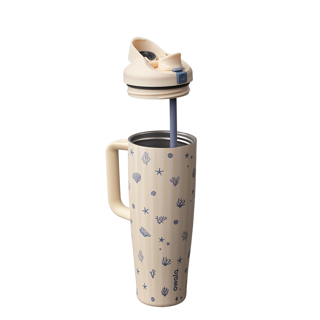 Owala FreeSip Tumbler 30oz in Coral Cabana, cream insulated stainless steel body with navy coral and seashell pattern, shown with cream lid lifted off and navy straw extended